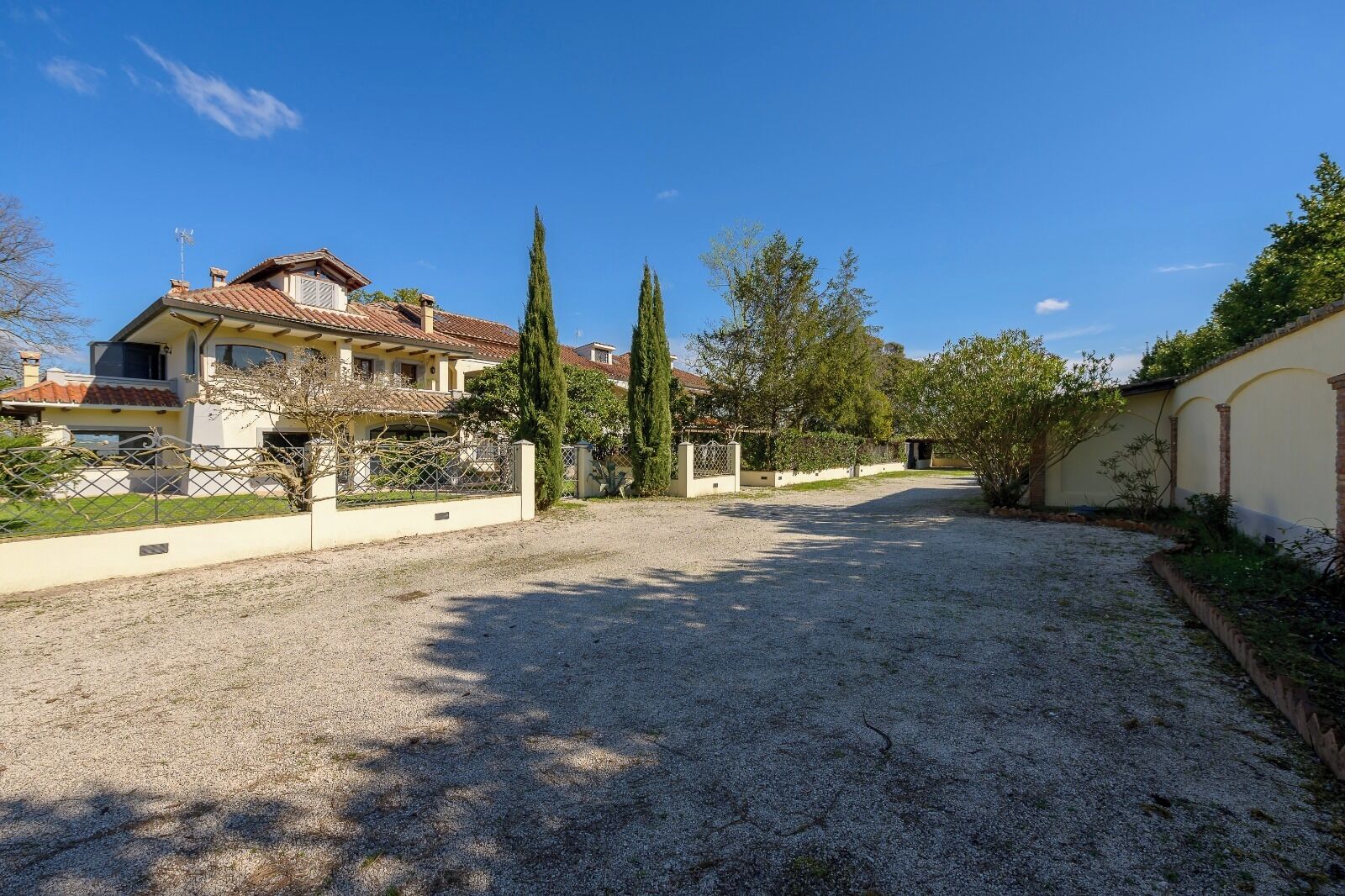 Il s’agit d’une propriété résidentielle dotée d’une allée gravillonnée, d’un jardin clôturé et d’une maison avec un toit en tuiles.