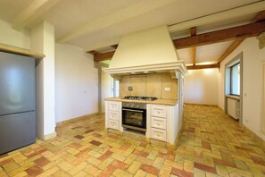A compact kitchen with a built-in stove, oven, and white cabinetry. - Villa delle Cese (Campagnano di Roma)