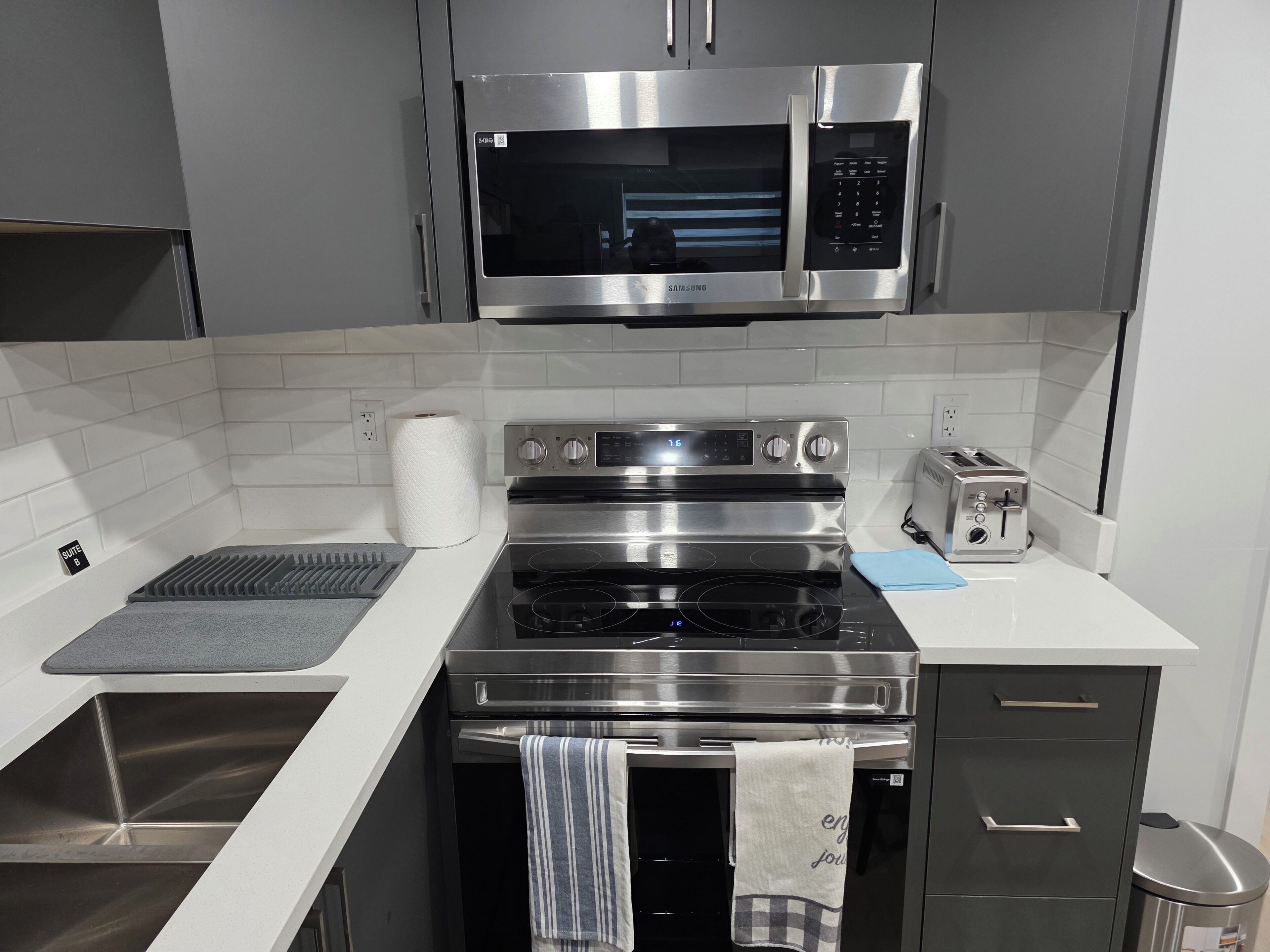 A modern kitchen with stainless steel appliances, a microwave, an oven, and a toaster.