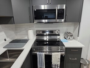 Eine moderne Küche mit Edelstahlgeräten, einer Mikrowelle, einem Backofen und einem Toaster.