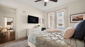 Ein Schlafzimmer mit Bett, Fernseher und Deckenventilator.