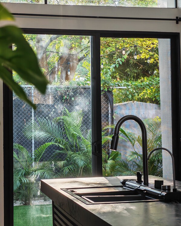 Una cocina moderna con un amplio ventanal, un lavamanos y un grifo.