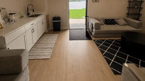 Et moderne interiør med et køkken, spiseområde og udsigt til en sø.