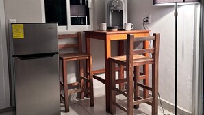 A compact kitchen with a refrigerator, a water dispenser, a table with chairs, and a lamp. - Cozy 1-bedroom studio in soothing Quimixto with AC (Quimixto)