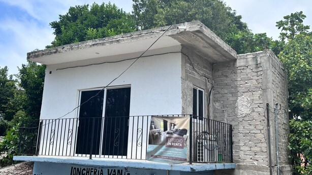 A small building with a balcony, a sign for a rental studio, and a stone wall. - Cozy 1-bedroom studio in soothing Quimixto with AC (Quimixto)