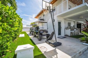 A modern house with a basketball hoop, a golf cart, and a barbecue area. - Private Beach, Waterfront, Islamorada, Island house with a pool & a boat dock (Islamorada)