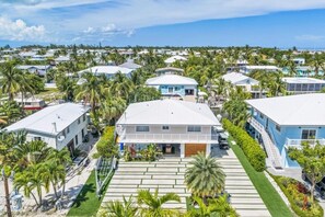 A residential area with houses, palm trees, and a clear sky. - Private Beach, Waterfront, Islamorada, Island house with a pool & a boat dock (Islamorada)