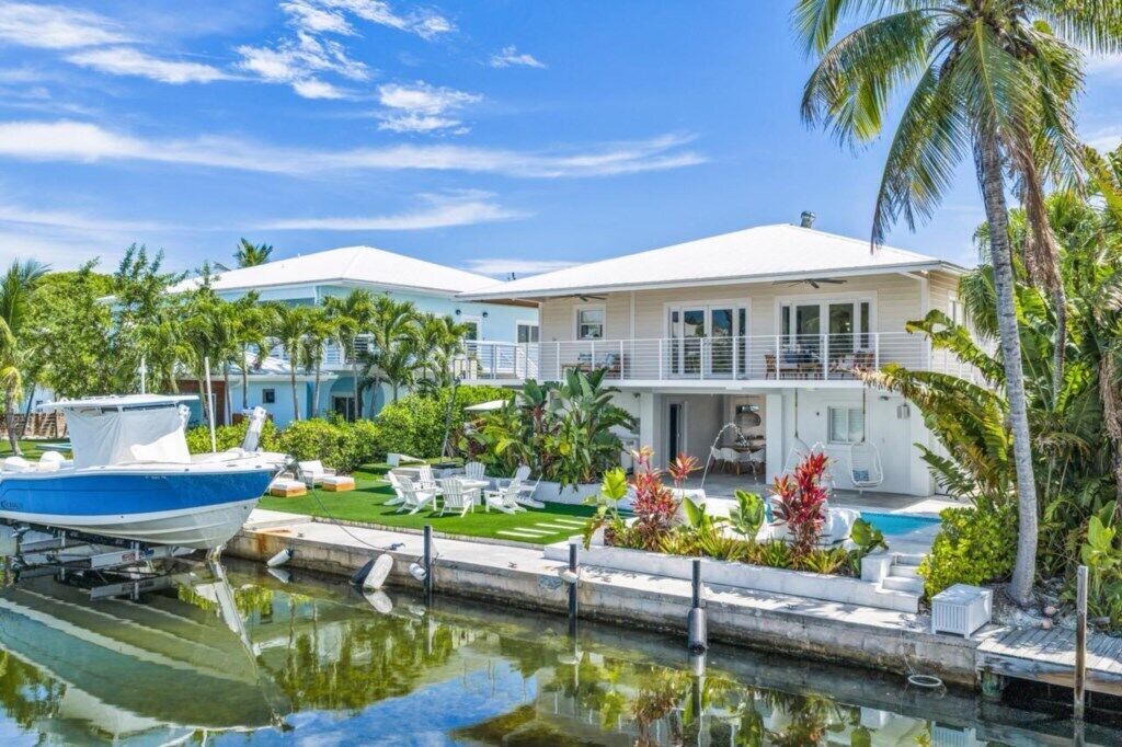 Une propriété située au bord de l’eau, dotée d’une piscine, d’un quai pour bateaux et d’un aménagement paysager luxuriant de style tropical.