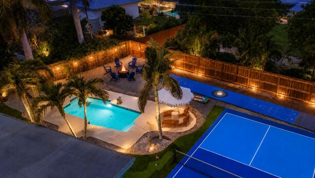 A backyard with a swimming pool, a fire pit, outdoor furniture, and a tennis court. - Coastal Cactus- Pool+Pickleball+Putting Green+Shuffleboard! (Manatee County)