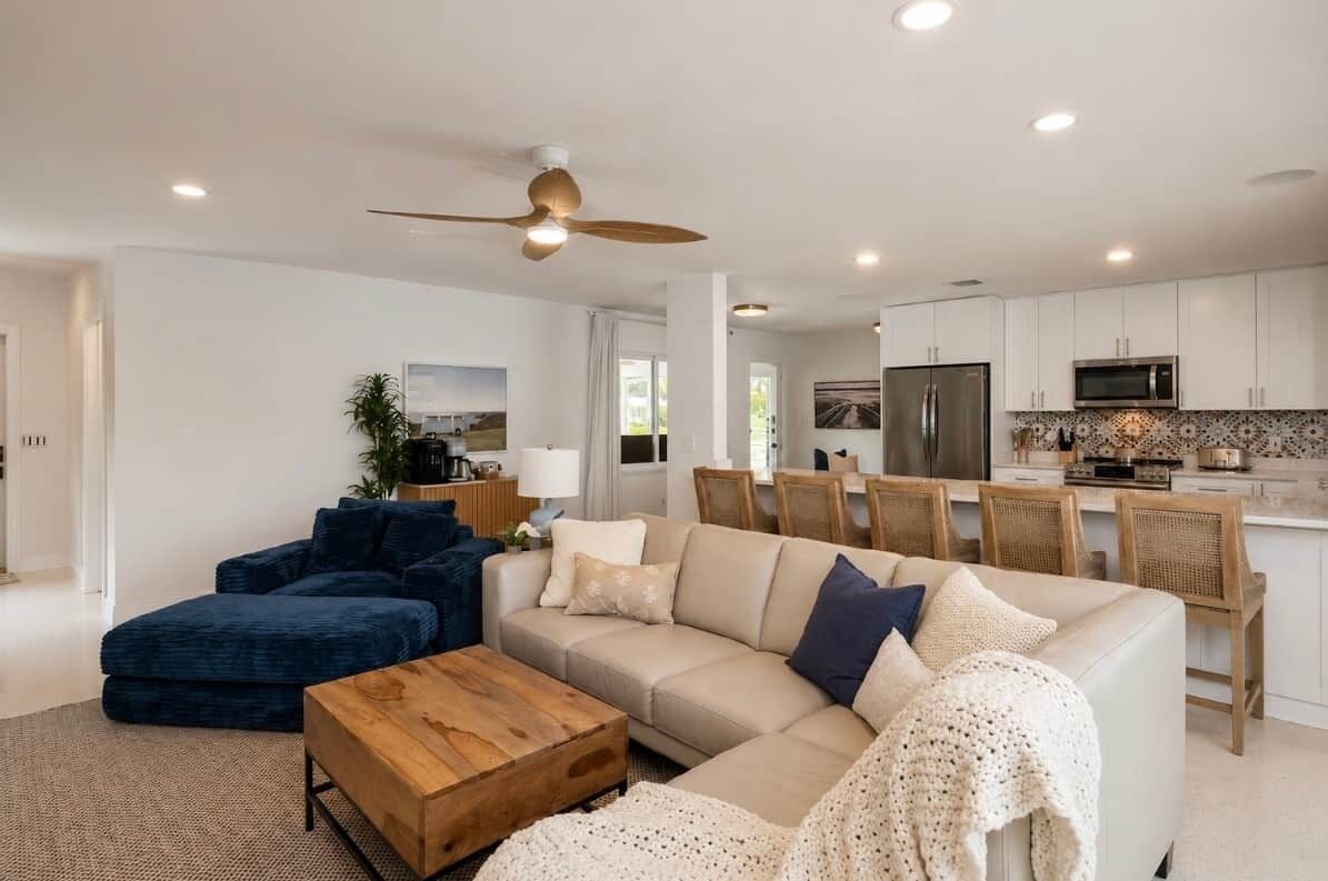 Ein modernes Wohnzimmer mit Sofa, Couchtisch und Deckenventilator.