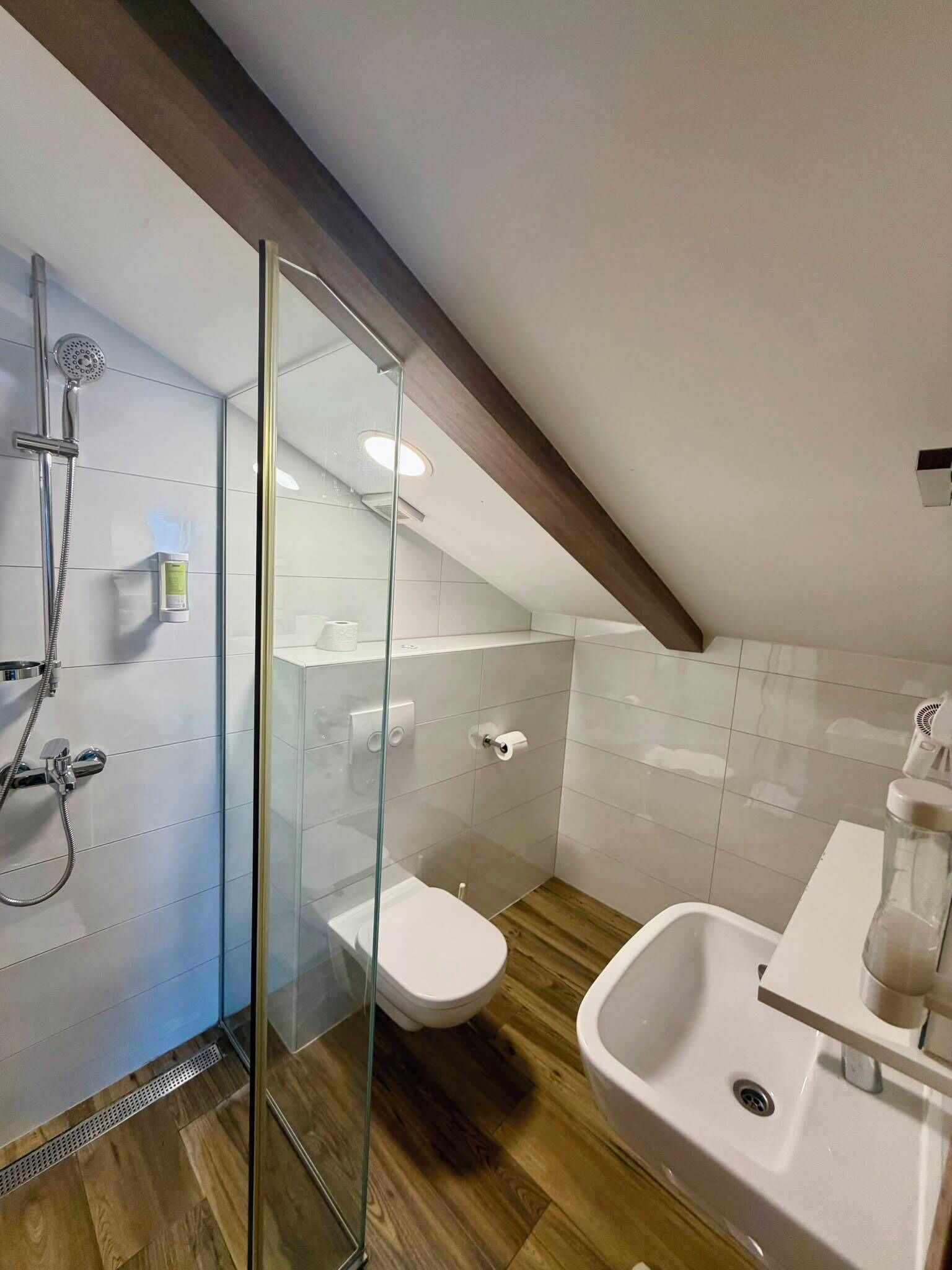 Une salle de bain moderne avec une douche à parois de verre, des toilettes et un lavabo.