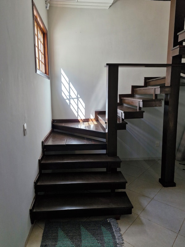 A staircase with a dark finish, leading to an upper floor.