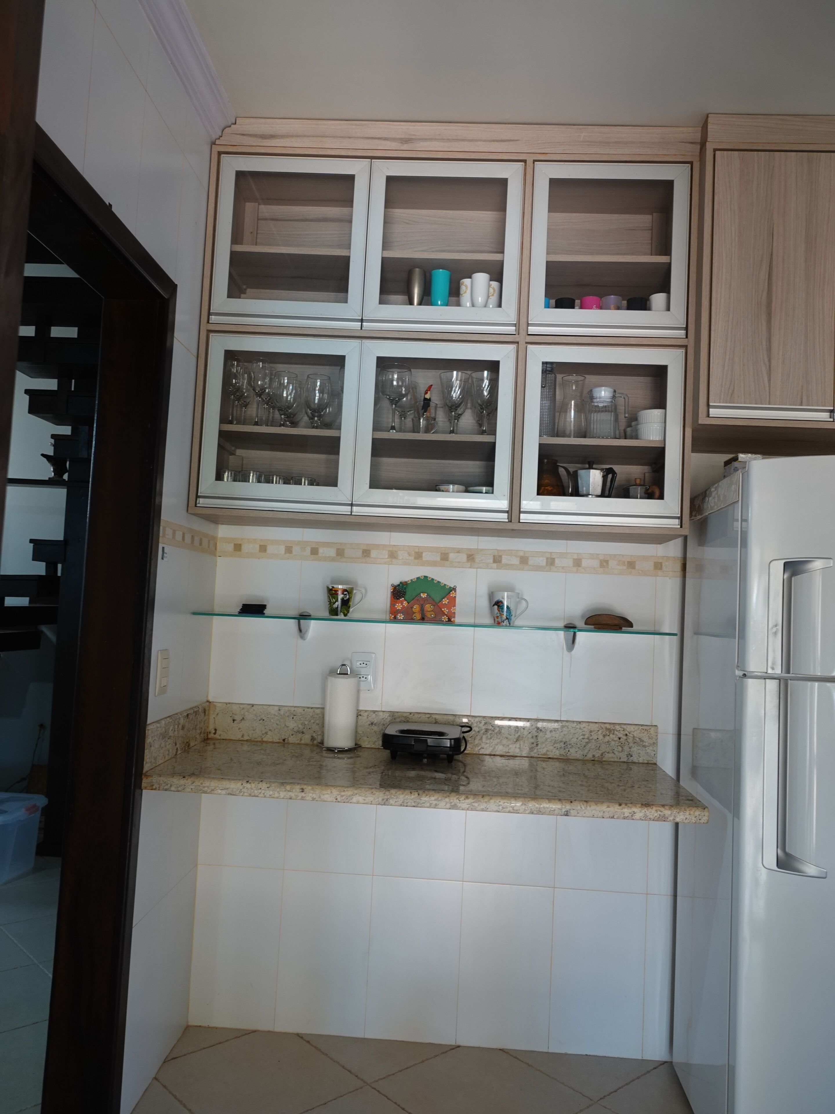 A kitchen with a built-in microwave, a coffee maker, and a toaster on the countertop.