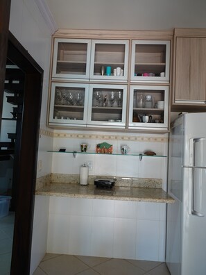 A kitchen with a built-in microwave, a coffee maker, and a toaster on the countertop.