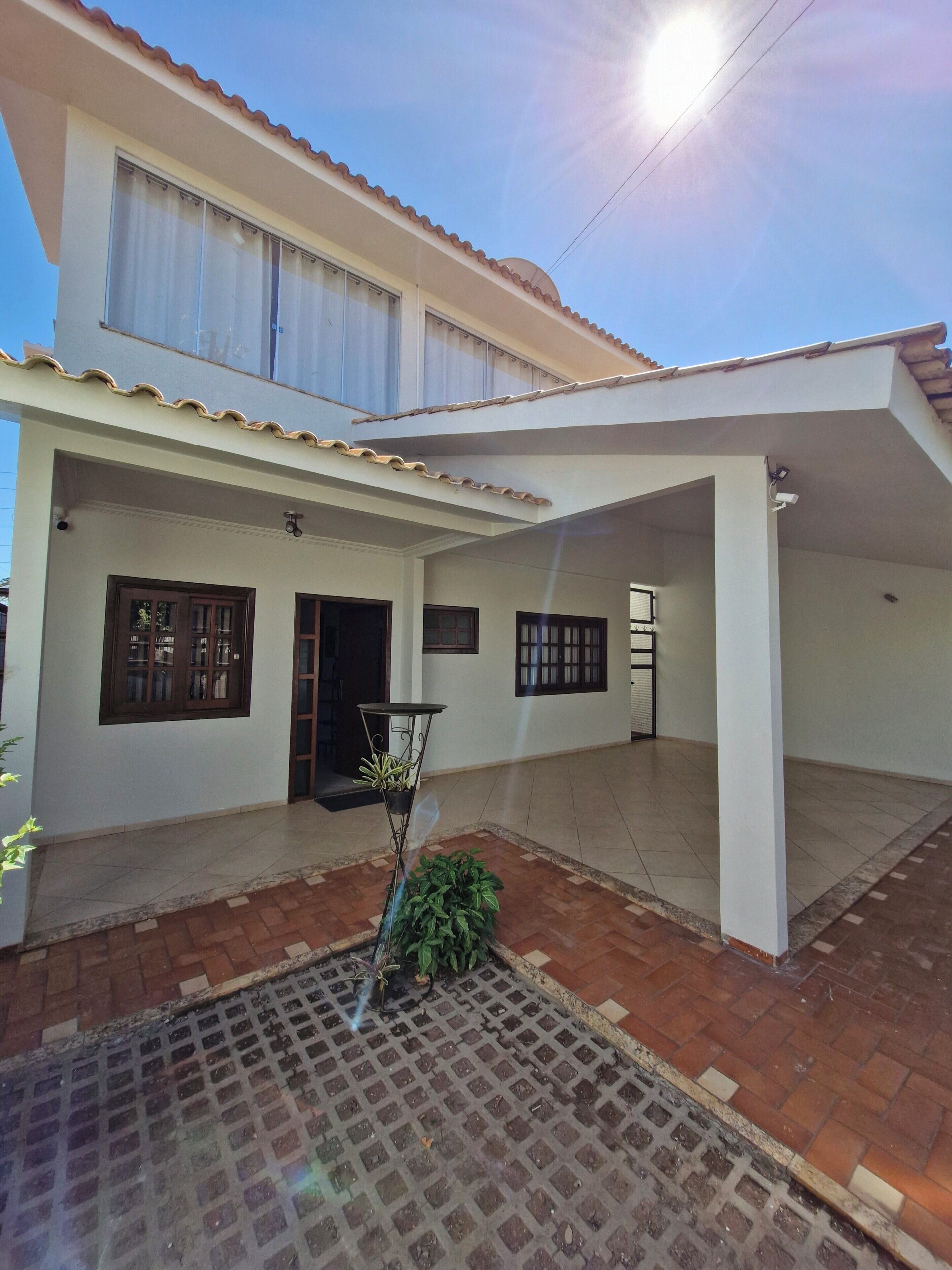 Una casa de dos pisos con un patio cubierto.