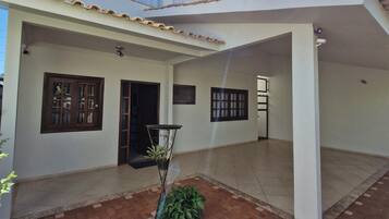 Una casa de dos pisos con un patio cubierto.