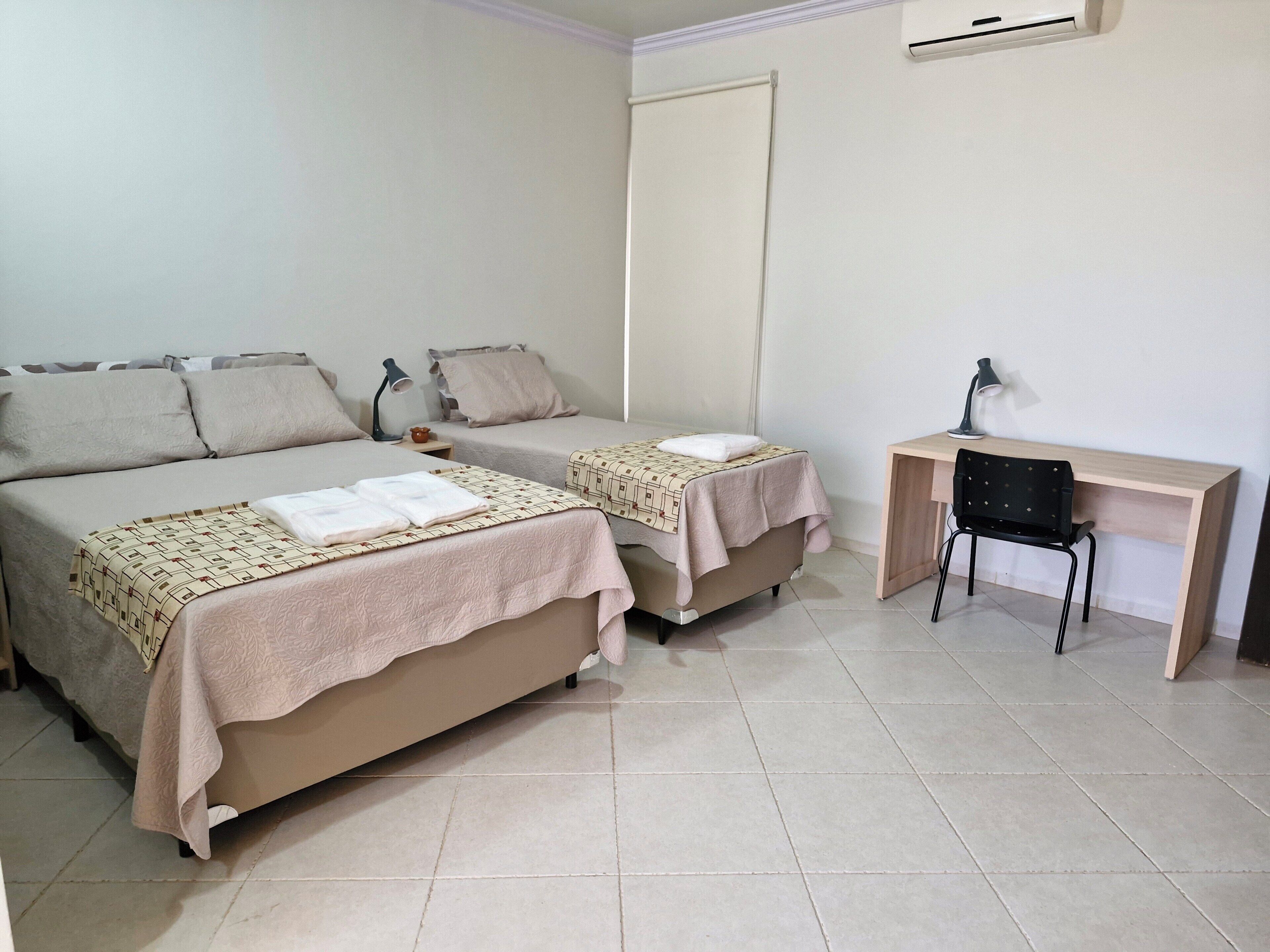 Una camera da letto con due letti, una scrivania e una sedia.