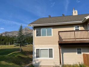 A two-story house with a balcony, a mountain view, and a fenced yard. - Big Sky Condo - Ski/Ride in Shuttle Out (Big Sky)