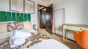 Ein Hotelzimmer mit Bett, Schreibtisch, Stuhl und Tür.