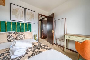 Ein Hotelzimmer mit Bett, Schreibtisch, Stuhl und Tür.