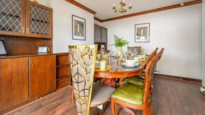 Ein Esszimmer mit Holztisch, Stühlen und einer Pendelleuchte.