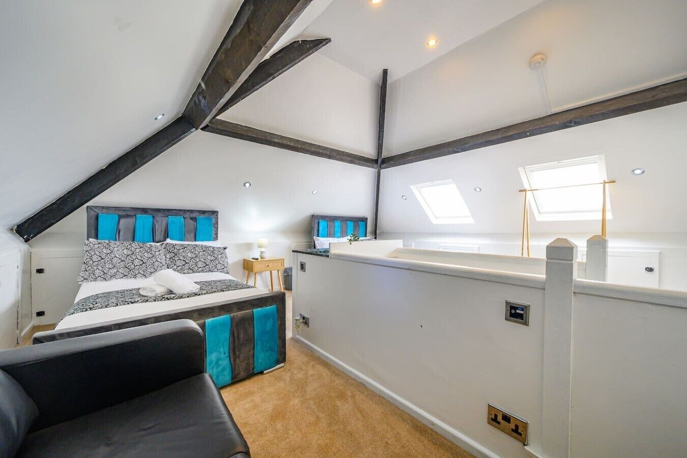 Een slaapkamer met een bed, nachtkastje en een klein bureau.