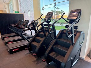 A fitness area with treadmills and a stationary bike, equipped with digital displays. - Luxury Couples Retreat - Sonoran Star Beachfront (Puerto Peñasco)