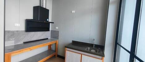 A modern kitchen with a built-in stove, a wooden countertop, and a sink.