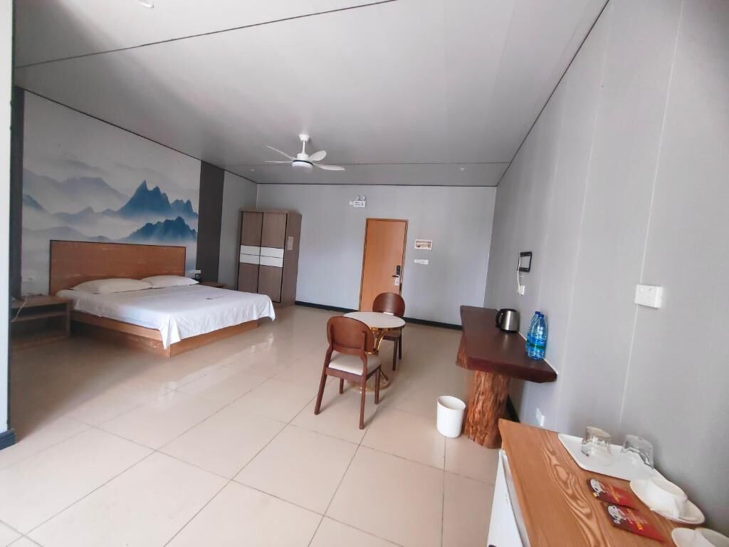 Una habitación de hotel con cama, escritorio, silla y mesa de comedor.