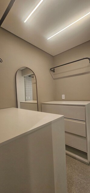A modern bathroom with a mirror, a towel rack, and a countertop. - Cond. Metro Casa Centro 101 (São Paulo)