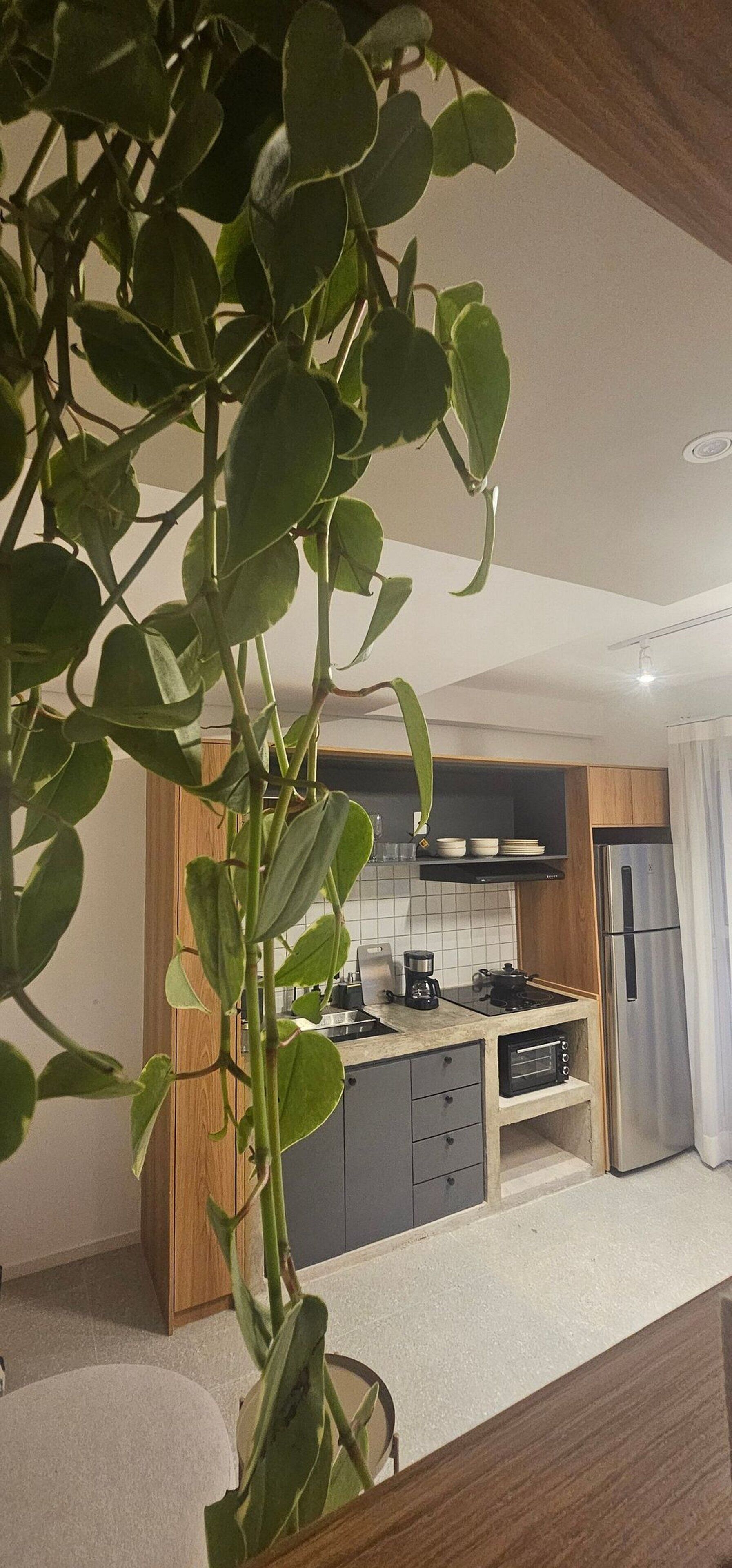 Una cocina moderna con una isla central, armarios de madera y un refrigerador de acero inoxidable.