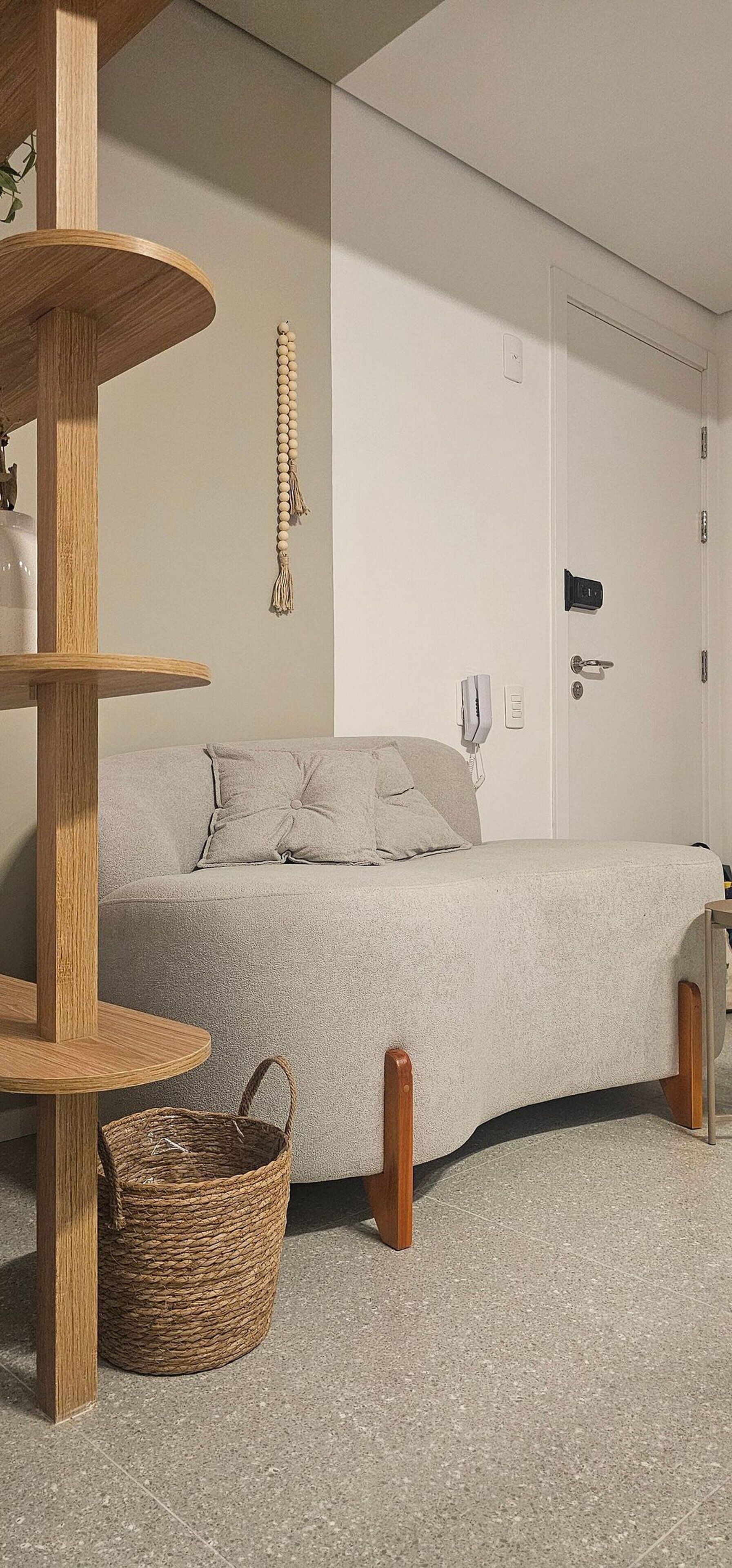 Ein stilvolles Zimmer mit einem Bett, einem Holzregal, einem gewebten Korb und einer Tür mit Schloss.