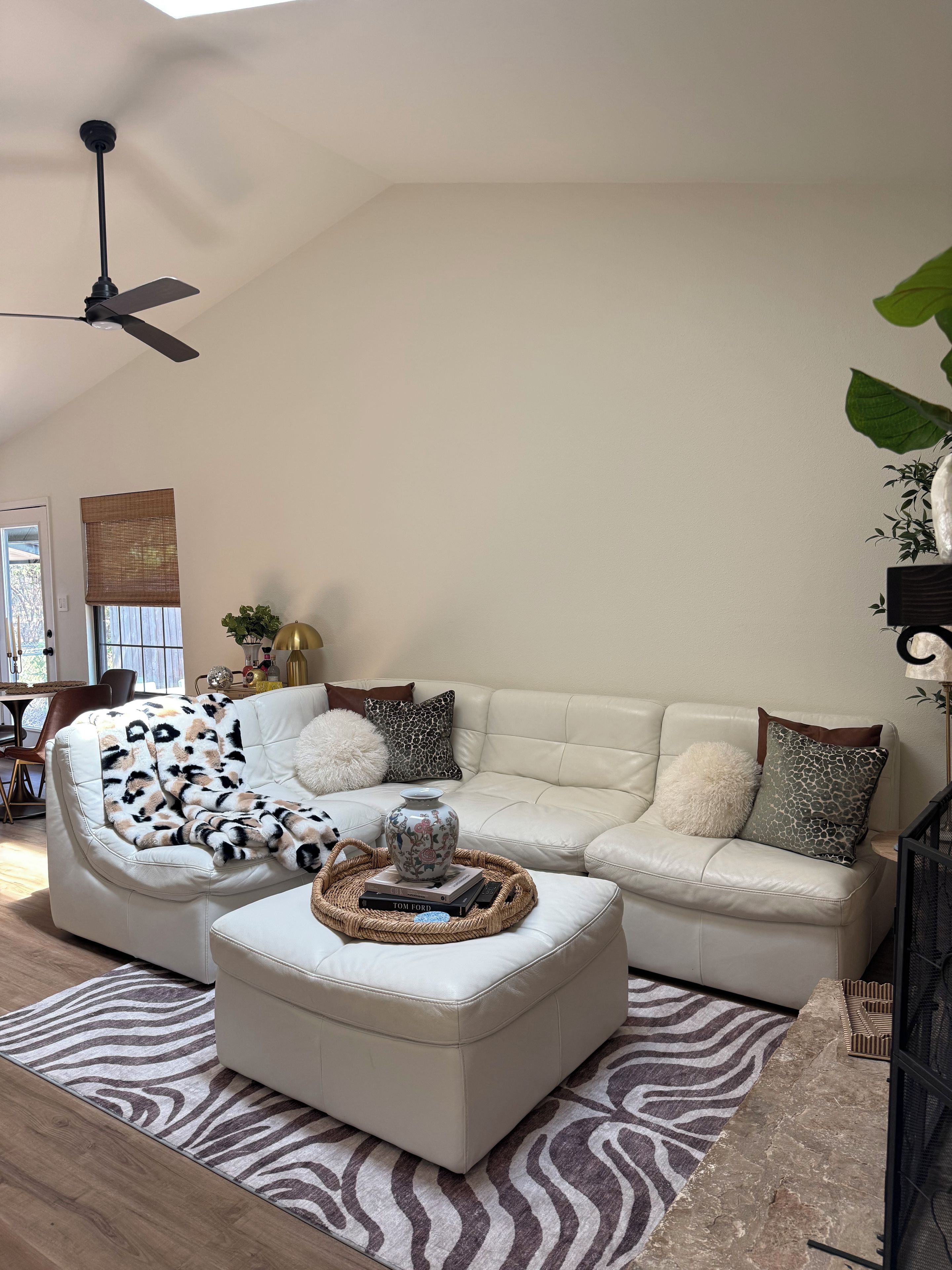 A modern living room with a sectional sofa, a round coffee table, and a zebra-patterned rug.