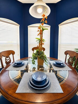 A dining table with a glass top, surrounded by chairs, and a central floral arrangement. - Family Villa, Private pool, cinema, and game room. (Davenport)