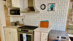 Una cocina compacta equipada con microondas, tostadora, cocina, horno y lavadora.
