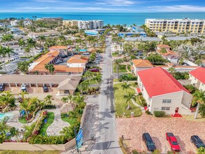 A coastal resort area with multiple buildings, a central road, and a view of the ocean. - Newly renovated 1-bed/bath condo sleeps 6! Walking distance to the beach! (Siesta Key)