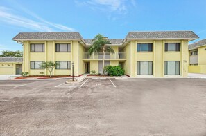 A two-story building with a flat roof, a central entrance, and a parking lot in front. - Newly renovated 1-bed/bath condo sleeps 6! Walking distance to the beach! (Siesta Key)