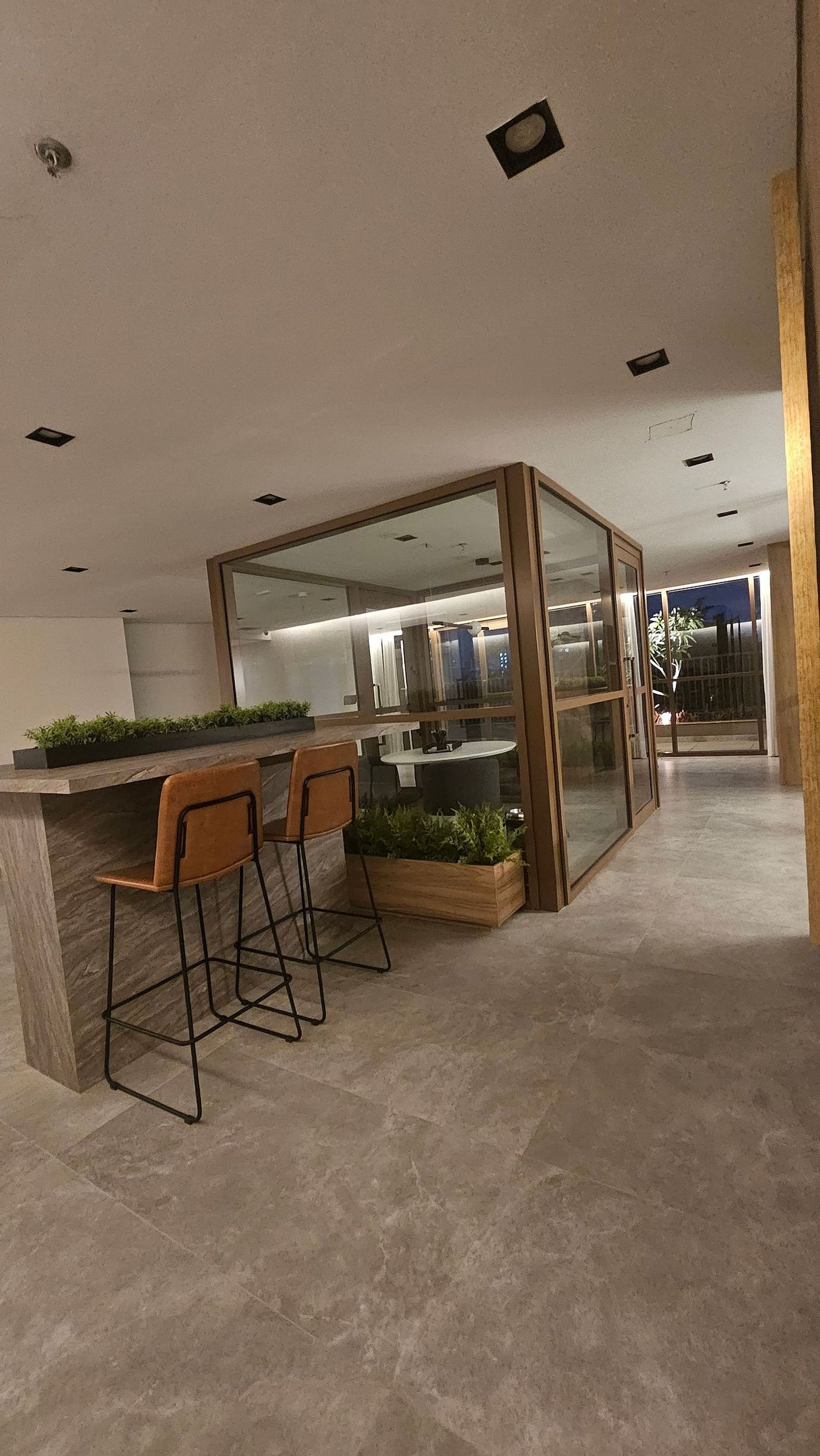 Ein modernes Interieur mit Barbereich, Sitzgelegenheiten und einer Glastrennwand.