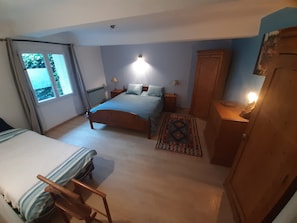 A bedroom with a bed, bedside tables, a wardrobe, and a window.