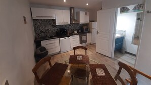 A compact kitchen with white cabinets, a microwave, and a coffee maker. - Charming village house in the heart of the Luberon—a typical village house in the Luberon region (Grambois)