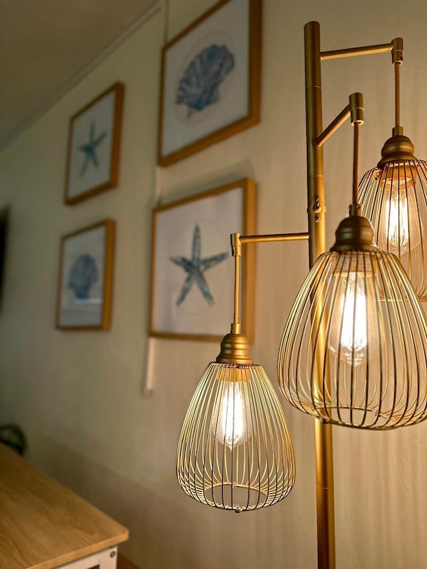 A room with a wall-mounted light fixture and framed artwork. - Oceanfront Studio, Beach & City Views, Jacuzzi, Heated Pool, Direct Beach Access (Daytona Beach)