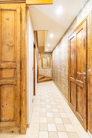 A hallway with wooden doors and a tiled floor. - La Ferme de la Galoppaz (THOIRY)