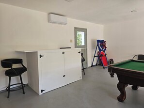 Ein Billardtisch, ein Billardqueue und ein Billardtisch mit grüner Spielvliesbahn.