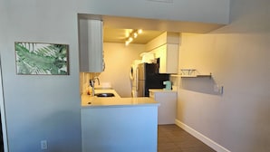 A compact kitchen with a central island, a built-in oven, and a microwave.