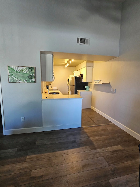 A compact kitchen with a central island, a built-in oven, and a microwave.