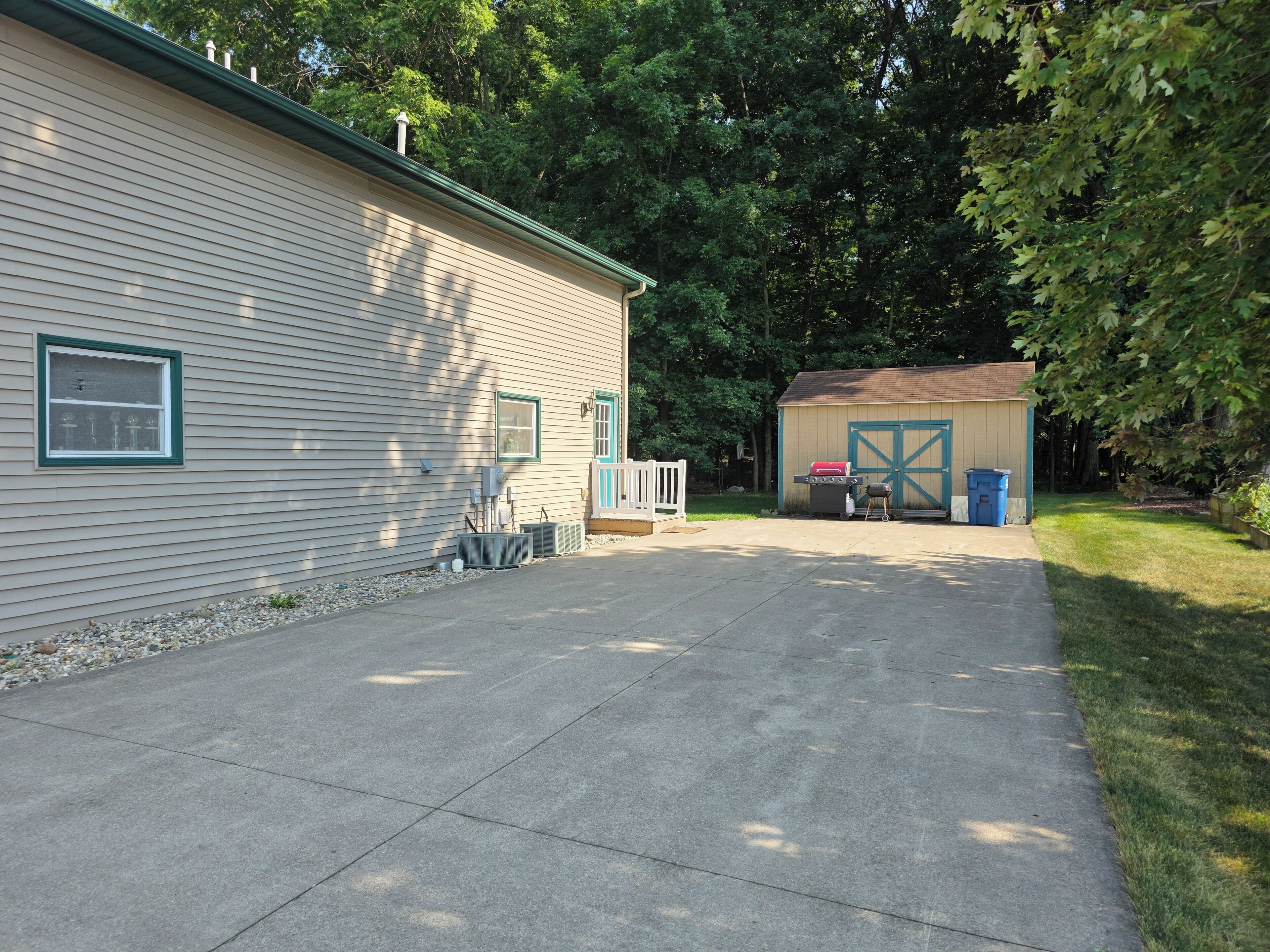 A residential property with a garage, a covered outdoor area, and a paved driveway.