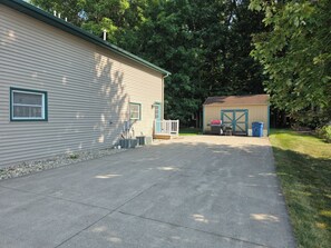 A residential property with a garage, a covered outdoor area, and a paved driveway.