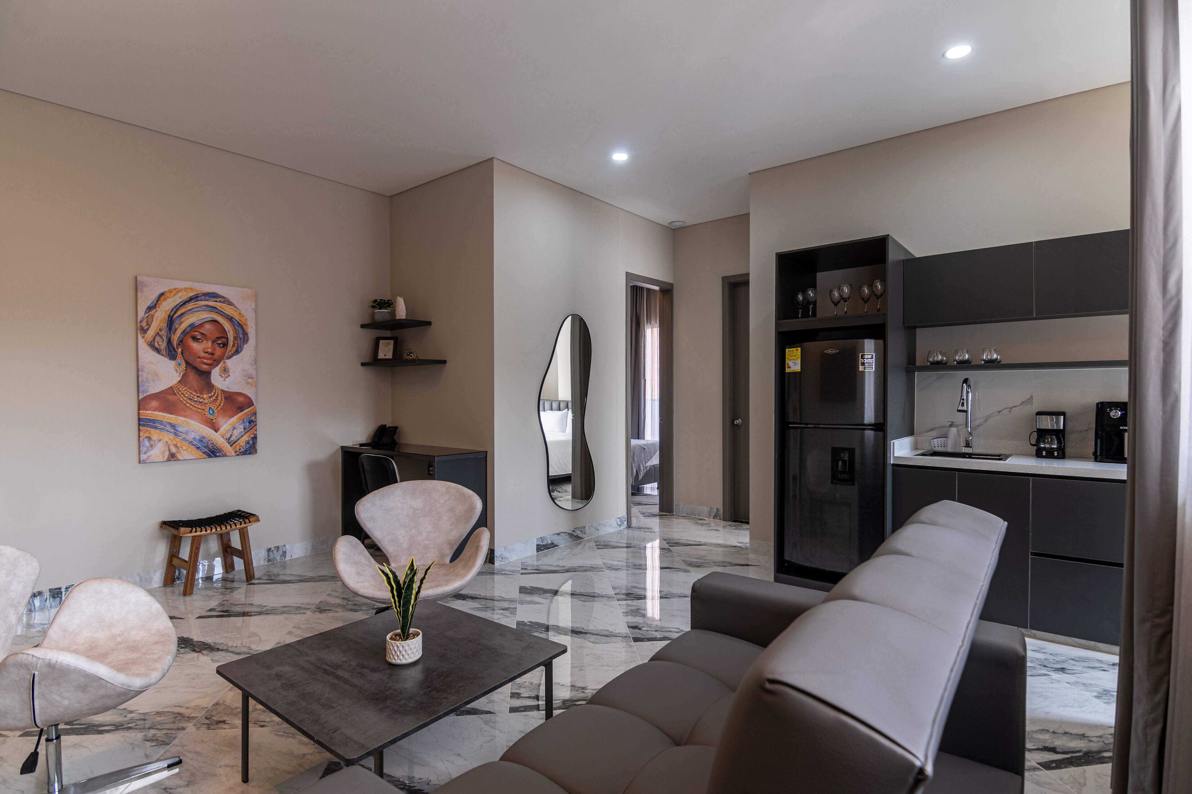 Un salon moderne avec un canapé, une table basse et un tableau accroché au mur.