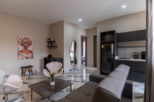 Una sala de estar moderna con un sofá, una mesa de centro y un cuadro en la pared.