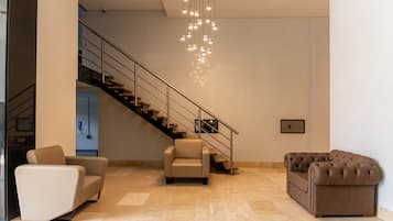 Ein modernes Interieur mit Treppe, zwei Sofas und einem Kronleuchter.